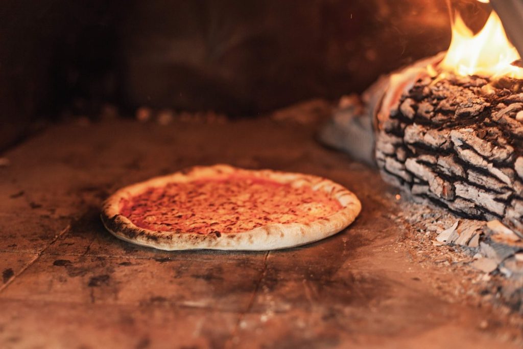 Pizza sül a fatüzelésű kemencében – illusztráció