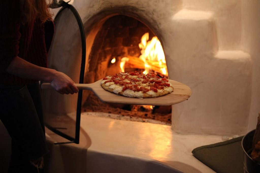 Pizza betétele a fatüzelésű kemencébe – illusztráció