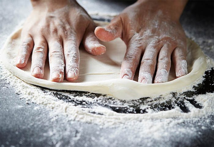 Pizzatészta nyújtása lisztes pulton – Pizza Accademia