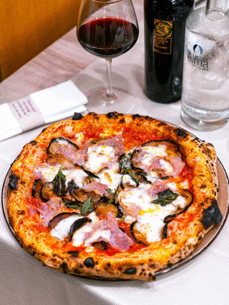 Pizza és vörösbor egy étterem asztalán – illusztráció