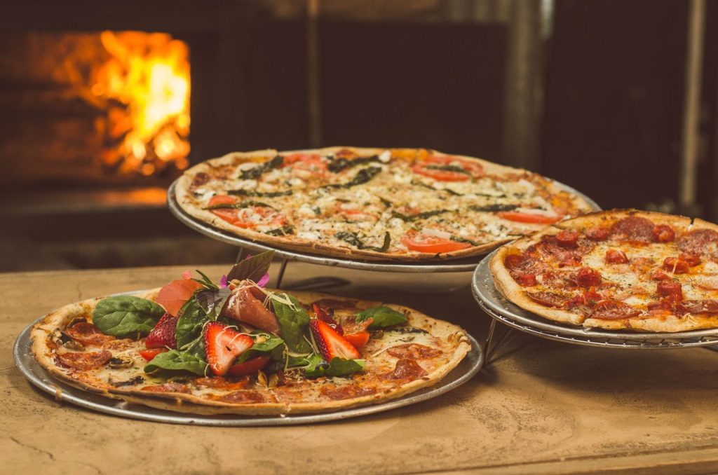 Friss pizzák a kemence mellett – illusztráció