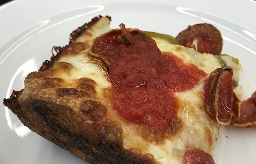 Detroiti pizza szelet ropogós, karamellizált sajtszéllel