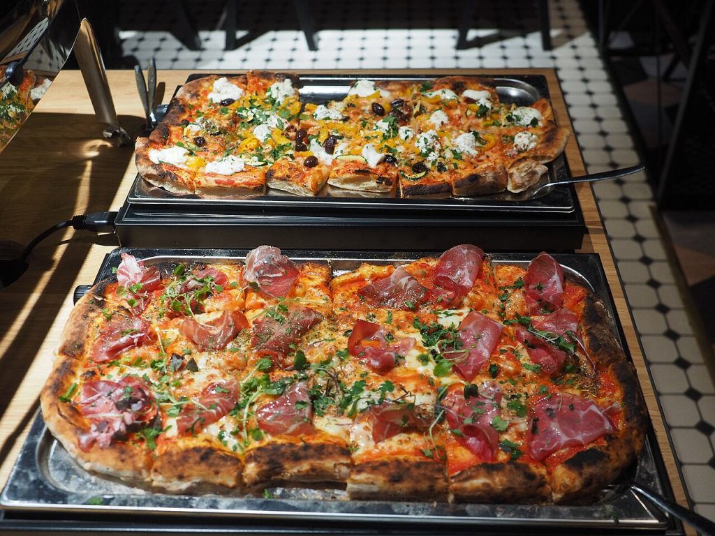 Pizza al taglio tepsikben a pultban